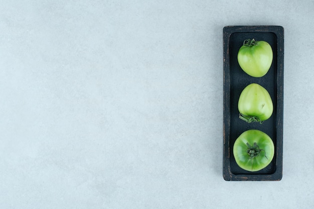 Gratis foto ingemaakte groene tomaten op zwarte plaat.