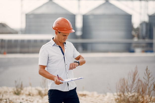 Gratis foto ingenieur in een halmet die zich door de fabriek bevindt