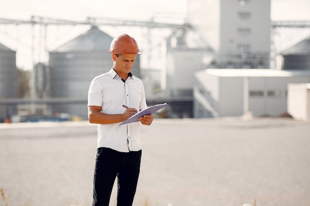 Gratis foto ingenieur in een helm die zich door de fabriek bevindt