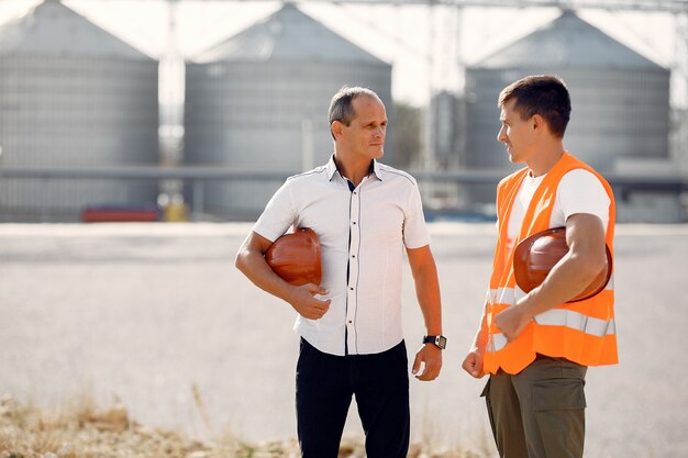 Ingenieurs met helmen staan door de fabriek