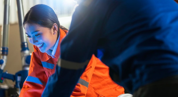 Gratis foto ingenieurssamenwerking twee aziatische mannelijke en vrouwelijke technicusonderhoud inspecteren relaisrobotsysteem met tabletlaptop om kwaliteit te controleren bedienen proceswerk zware industrie 40 productiefabriek