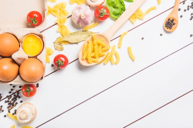 Ingrediënten voor het maken van pasta op witte plank achtergrond