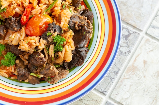 Inheems ghanees, afrikaans-caraïbisch eten jollof rice met tomatensaus, regionale kruiden, kippenvlees en slachtafval.