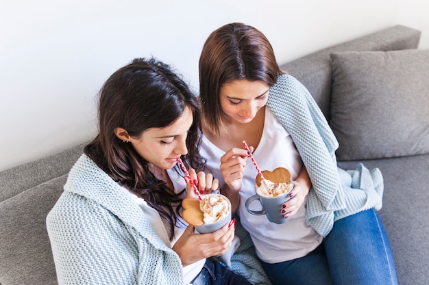 Inhoud vrouwen die knuffelen en koffie drinken