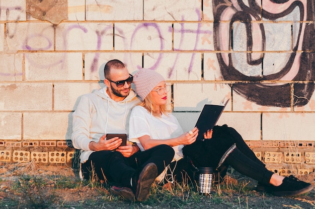 Gratis foto inhoudspaar ontspannen met boek en gadget