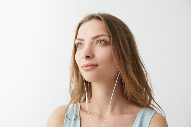 Inschrijving dromerig jong mooi meisje dromen luisterend naar het streamen van muziek in de koptelefoon.