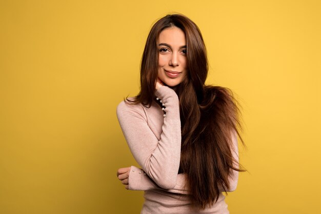 inschrijving mooi meisje met donker haar roze shirt poseren dragen Studio shot van zalige brunette vrouw.