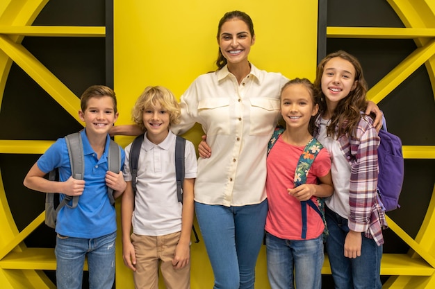 Instructeur en schoolkinderen poseren voor de camera in de lobby