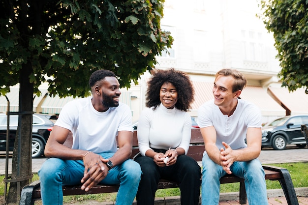 Interculturele vrienden in park zitten en chatten