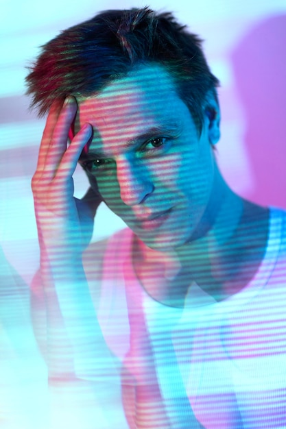 Gratis foto interieur portret van knappe man in vaporwave stijl