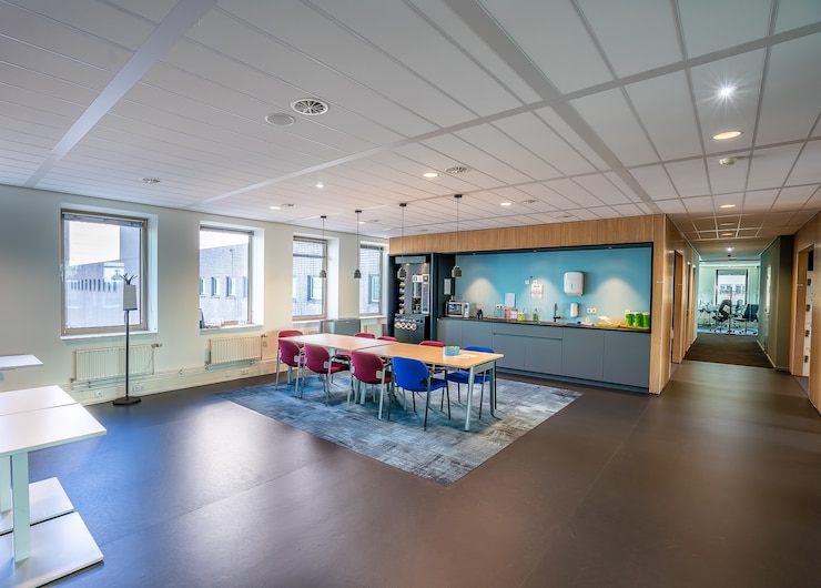 Gratis Foto interieur van de keuken van een modern kantoor met een lange houten tafel en stoelen