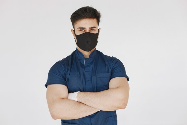 Internationale medische student. Man in een blauw uniform. Arts met een masker.