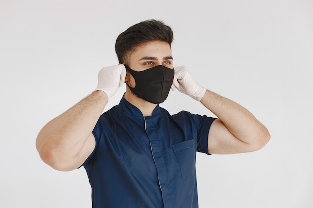 Internationale medische student. man in een blauw uniform. arts met een masker.