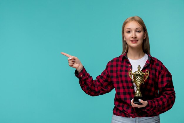 Internationale studentendag schattig jong meisje in rood geruit overhemd dat naar links wijst en een trofee vasthoudt