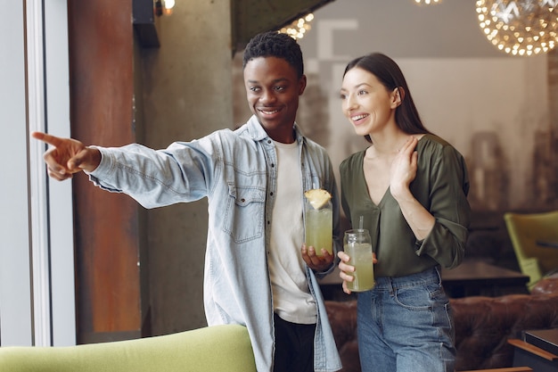 Internationals mensen staan in een cafe en drinken een cocktail