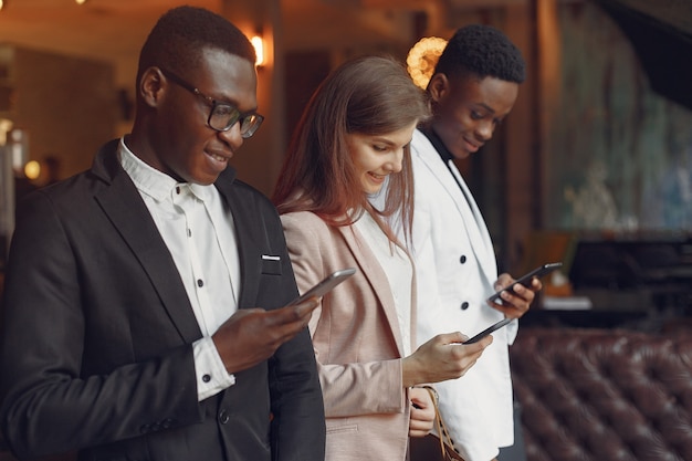 Internationals mensen staan in een cafe met mobiele telefoon