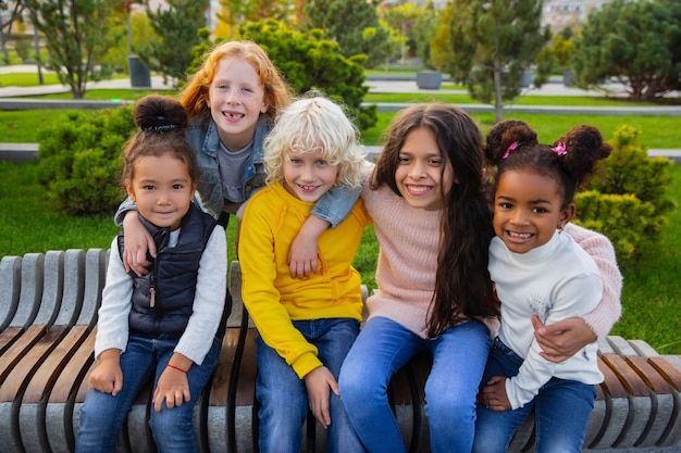 Gratis foto interraciale groep kinderen, meisjes en jongens die samen spelen in het park in de zomerdag