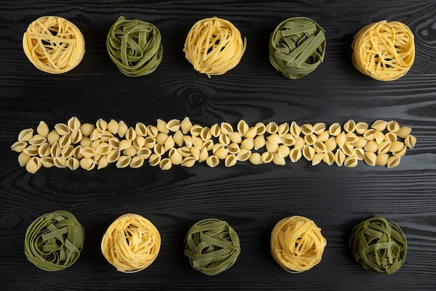 Gratis foto italiaanse pasta variëteiten op de zwarte tafel