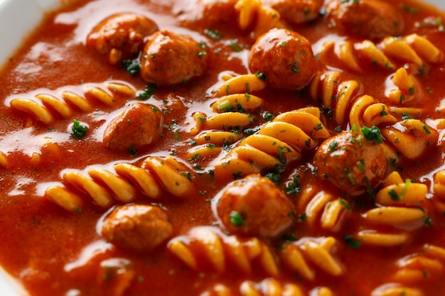 Italiaanse tomatensoep met noedelsdeegwaren en gehaktballen die op plaat worden gediend.