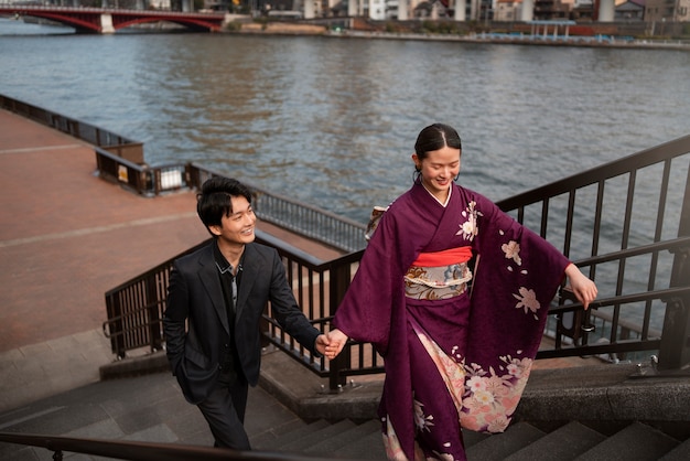 Gratis foto japans stel poseert bij de brug en viert de volwassenheidsdag