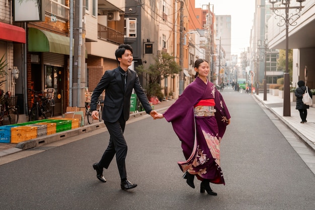 Gratis foto japans stel viert volwassenheidsdag en poseert buiten in de stad