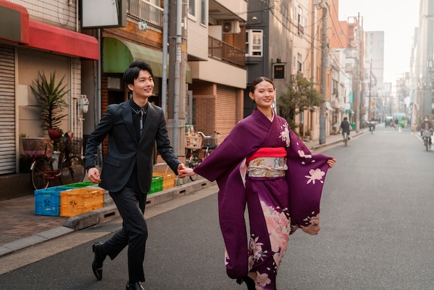 Gratis foto japans stel viert volwassenheidsdag en poseert buiten in de stad
