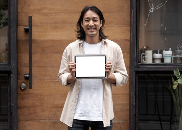 Japanse ontwerper met een digitaal tabletscherm buiten zijn sh