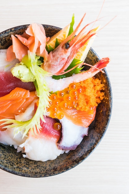 Japanse rijstkom met sashimi zeevruchten bovenop