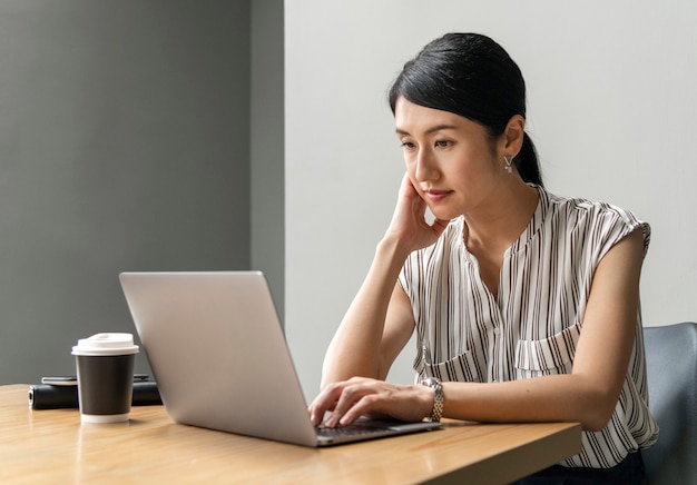 Japanse vrouw die aan laptop werkt