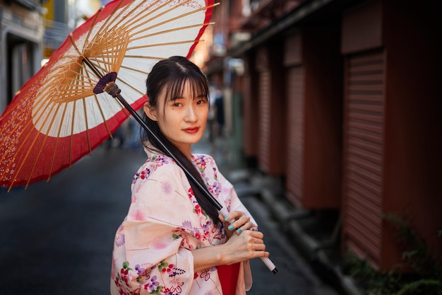 Gratis foto japanse wagasa-paraplu geholpen door jonge vrouw