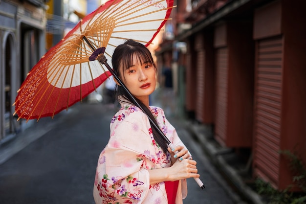 Gratis foto japanse wagasa-paraplu geholpen door jonge vrouw