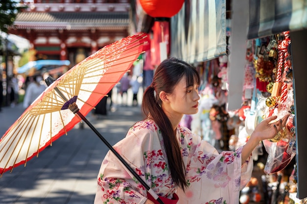 Gratis foto japanse wagasa-paraplu geholpen door jonge vrouw