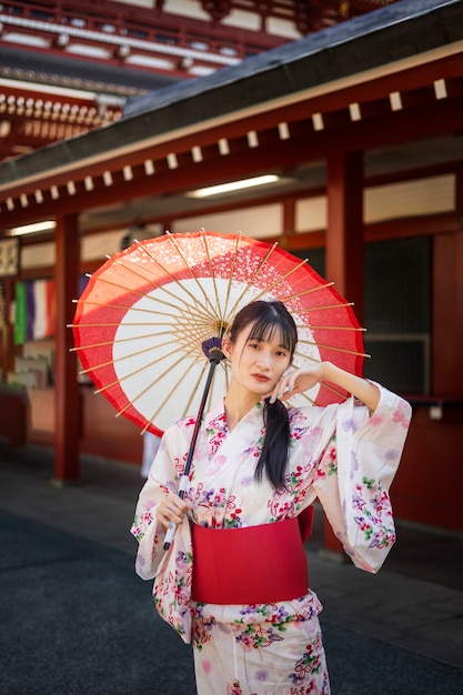 Gratis foto japanse wagasa-paraplu geholpen door jonge vrouw