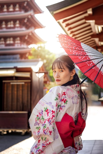 Gratis foto japanse wagasa-paraplu geholpen door jonge vrouw