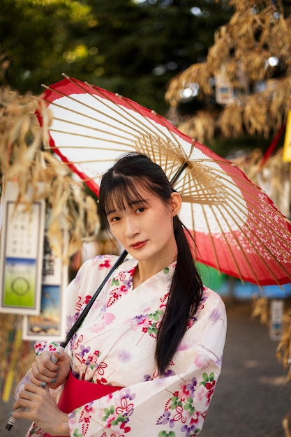 Gratis foto japanse wagasa-paraplu geholpen door jonge vrouw