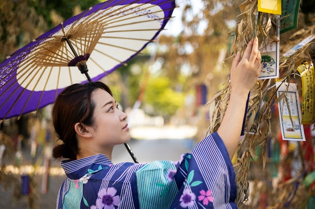 Gratis foto japanse wagasa-paraplu geholpen door jonge vrouw