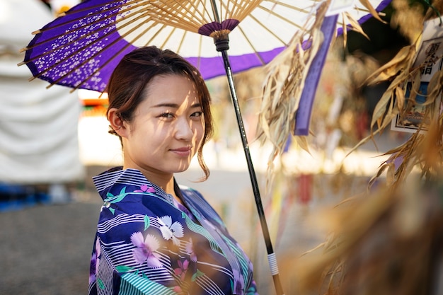 Gratis foto japanse wagasa-paraplu geholpen door jonge vrouw