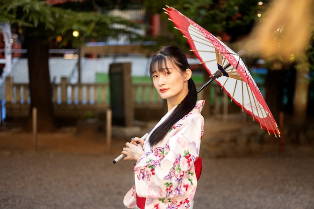 Gratis foto japanse wagasa-paraplu geholpen door jonge vrouw