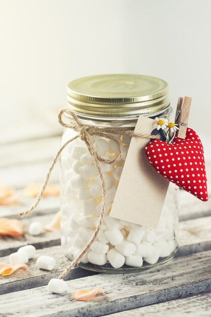 Jar met marshmallow en rode pluche hart. Liefde, zoet of Valenti