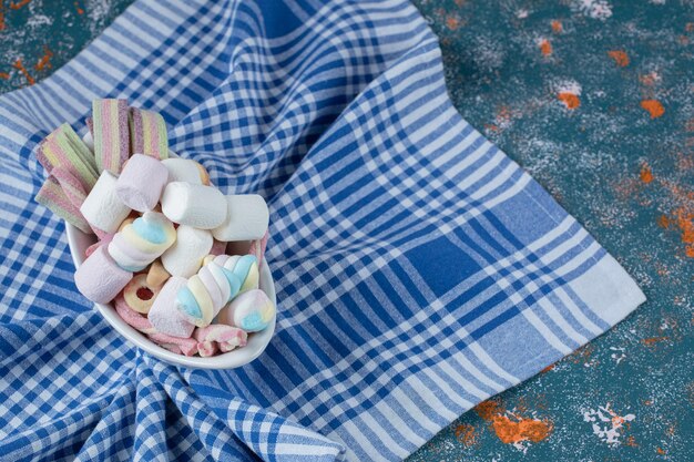 Jellybeans en marshmallows op witte keramische plaat.