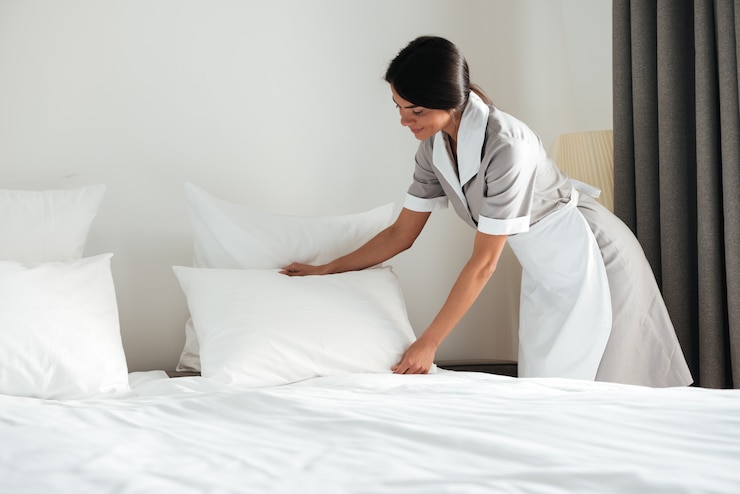 Gratis Foto jong de vestigingshoofdkussen van het hotelmeisje op bed