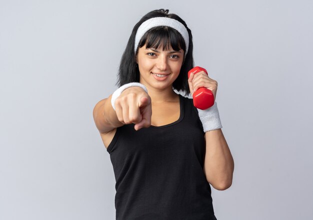 Jong fitnessmeisje met een hoofdband die een halter vasthoudt en oefeningen doet die er zelfverzekerd uitzien