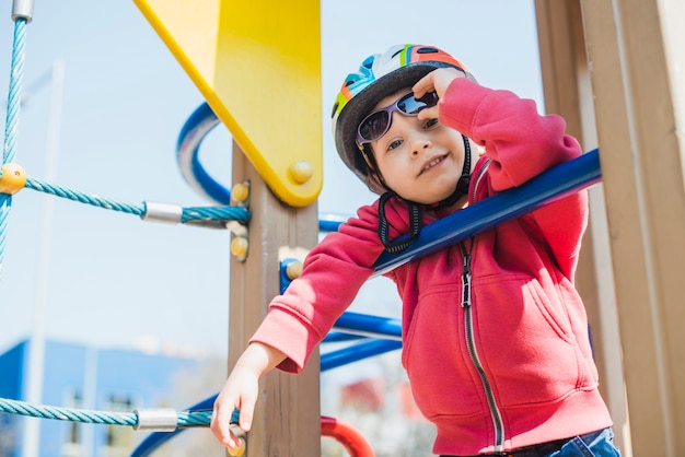 Gratis foto jong geitje buiten spelen op speelplaats