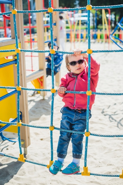 Gratis foto jong geitje buiten spelen op speelplaats