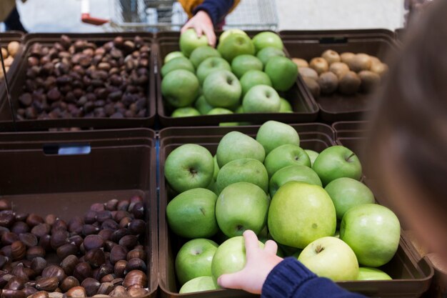 Jong geitje dat groene appel van plank neemt