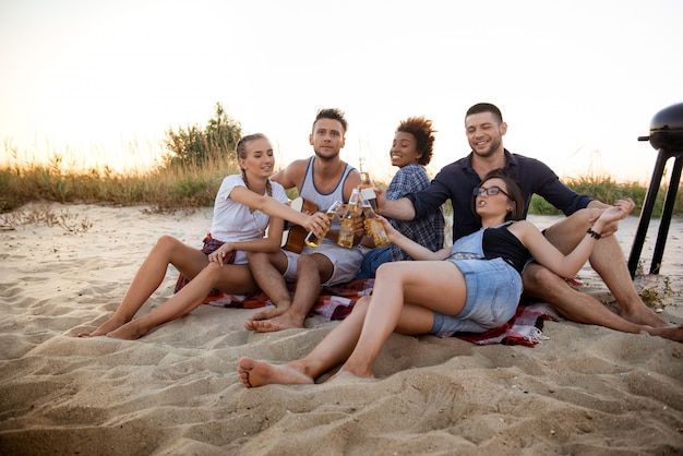 Jong gezelschap van vrienden vreugde, rust op het strand tijdens zonsopgang