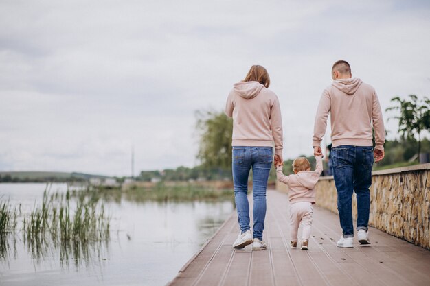 Jong gezin met hun kleine baby kind in park aan het meer