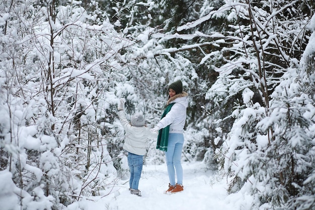 Jong gezin voor een wandeling. moeder en dochter lopen in een winterpark.