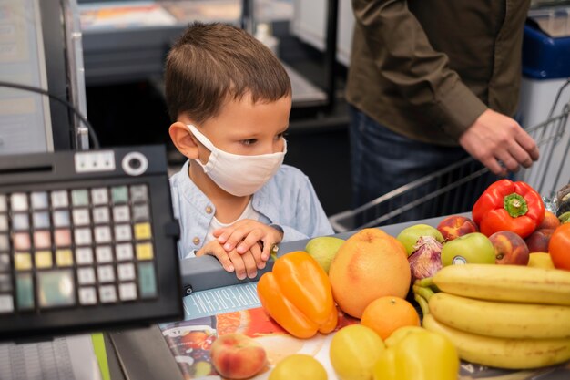 Jong kind winkelen met gezichtsmasker