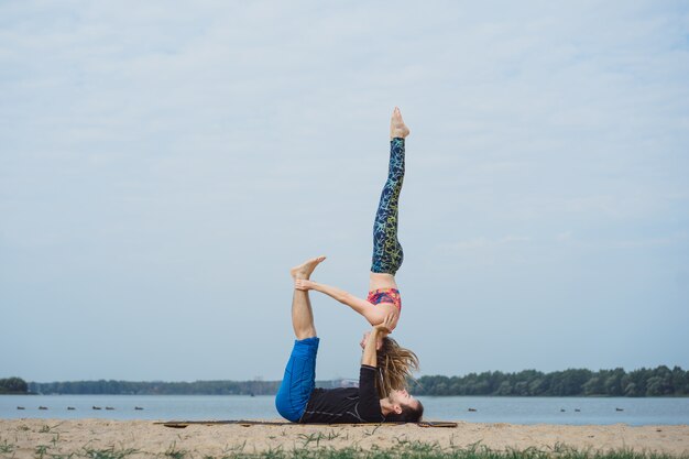 jong koppel beoefenen van yoga op stad achtergrond